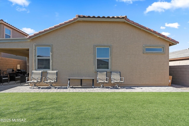 back of property featuring a patio and a lawn