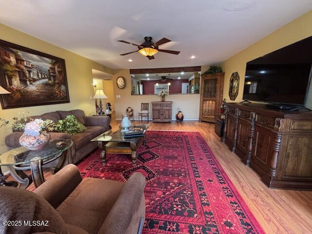 living room with light hardwood / wood-style floors and ceiling fan