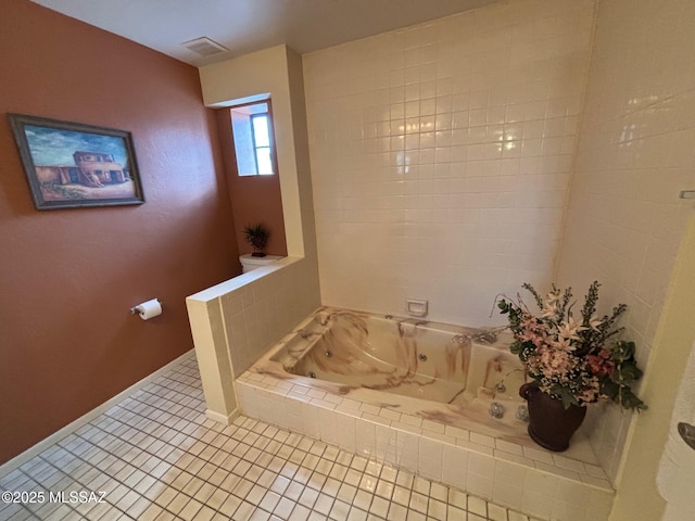 bathroom featuring tile patterned flooring and tiled tub