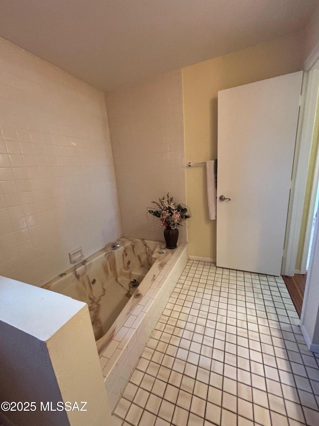 bathroom featuring tiled bath and tile patterned flooring