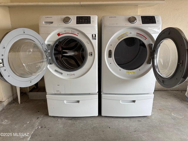 clothes washing area featuring separate washer and dryer