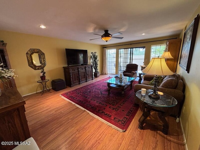 living room with ceiling fan and light hardwood / wood-style flooring