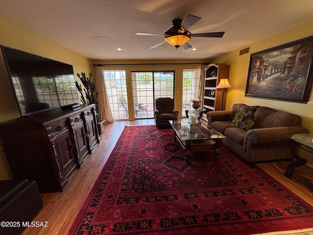 living room featuring wood-type flooring and ceiling fan