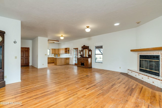 unfurnished living room with light hardwood / wood-style flooring and a textured ceiling