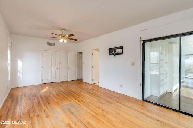 empty room with ceiling fan and light hardwood / wood-style flooring