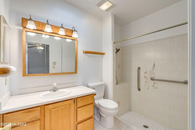 bathroom featuring vanity, tiled shower, tile patterned floors, and toilet