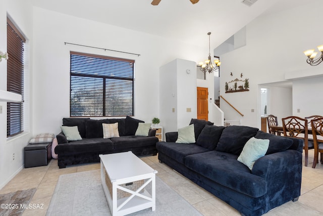 living room with light tile patterned flooring, a towering ceiling, and ceiling fan with notable chandelier