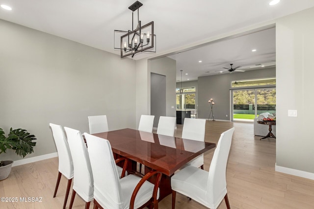 dining space with ceiling fan with notable chandelier and light wood-type flooring