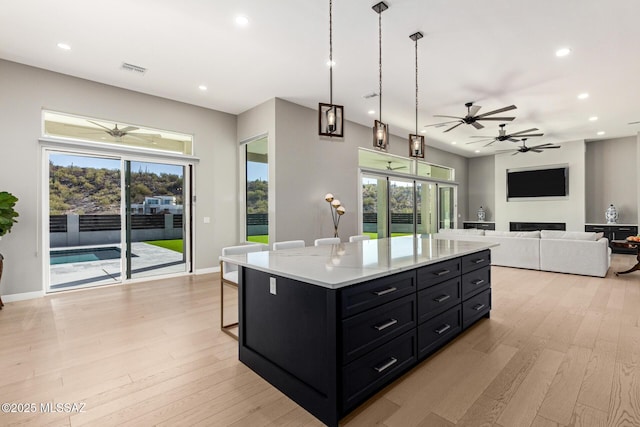 kitchen featuring pendant lighting, a center island, light hardwood / wood-style flooring, and a wealth of natural light