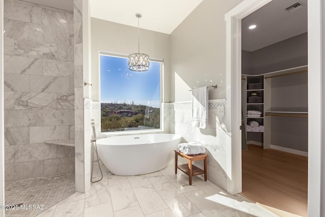 bathroom featuring separate shower and tub, tile walls, and an inviting chandelier