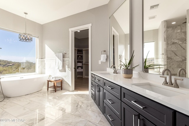 bathroom with vanity, a chandelier, and plus walk in shower