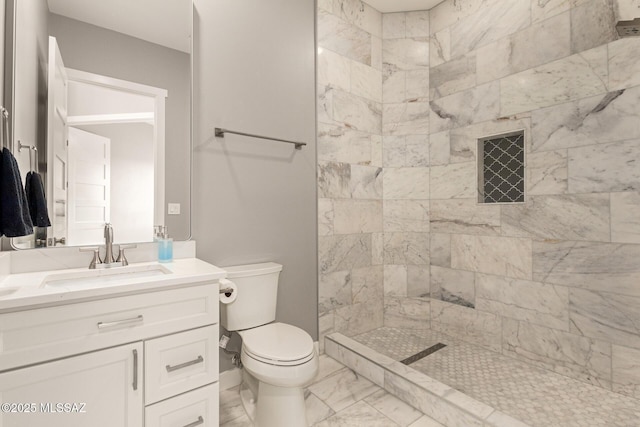 bathroom with vanity, toilet, and a tile shower