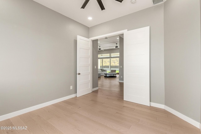 empty room with light hardwood / wood-style flooring and ceiling fan