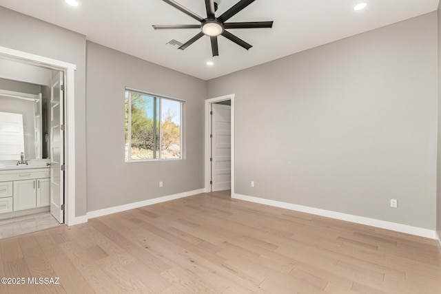 unfurnished bedroom featuring ceiling fan, connected bathroom, sink, and light wood-type flooring