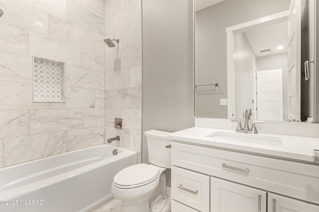 full bathroom featuring tiled shower / bath, vanity, and toilet