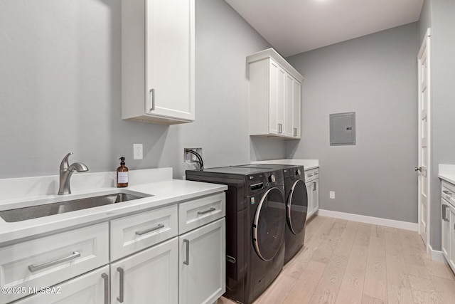 laundry room with washer and dryer, sink, cabinets, electric panel, and light hardwood / wood-style floors