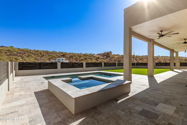 view of swimming pool with a patio, ceiling fan, and an in ground hot tub