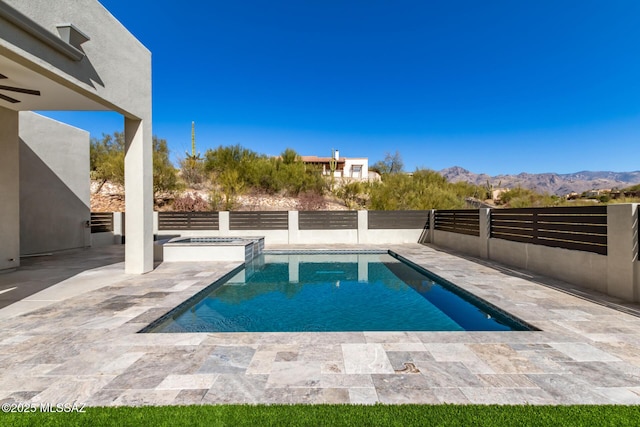 view of pool with an in ground hot tub, a mountain view, and a patio area