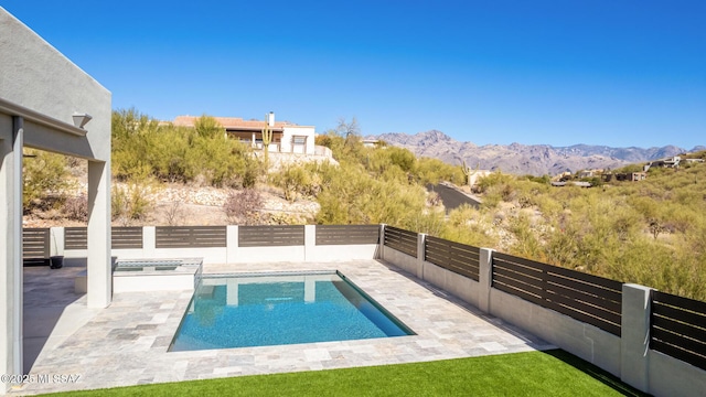 view of swimming pool with a patio and a mountain view