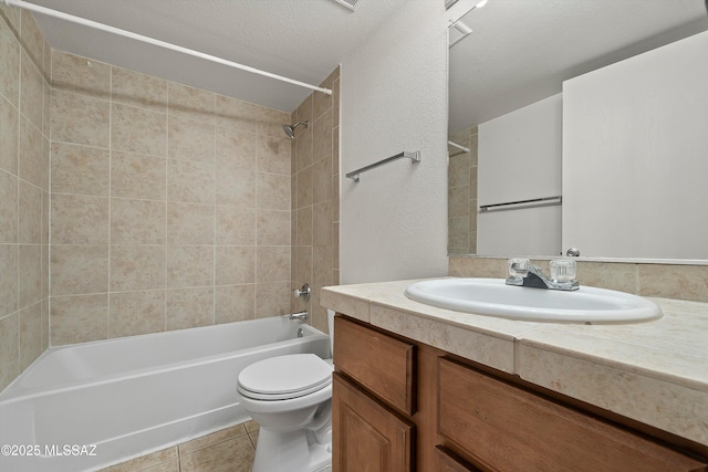 full bathroom with tiled shower / bath combo, vanity, a textured ceiling, tile patterned floors, and toilet