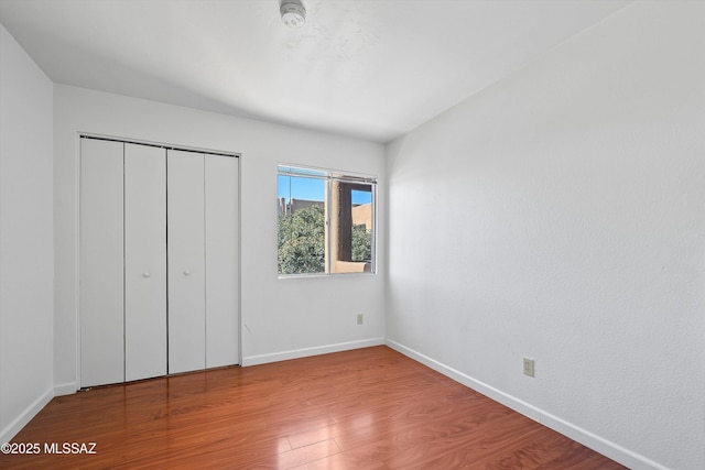 unfurnished bedroom featuring hardwood / wood-style floors and a closet