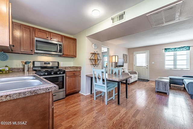 kitchen with hardwood / wood-style floors, stainless steel appliances, and sink