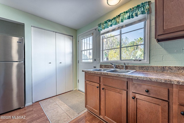 kitchen with sink, hardwood / wood-style flooring, and stainless steel fridge