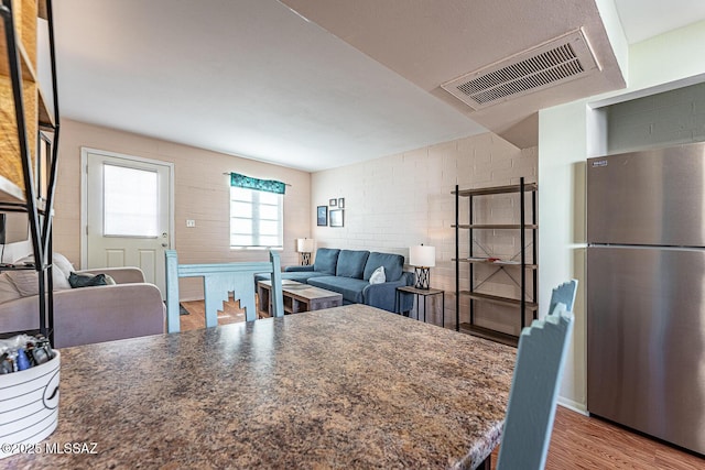 kitchen featuring light wood-type flooring and stainless steel fridge