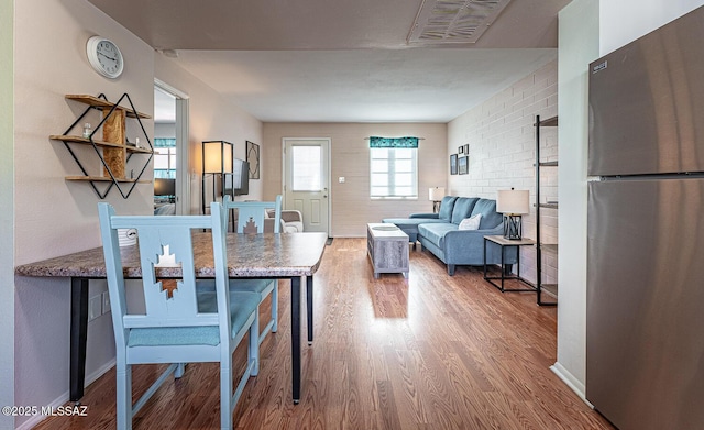 interior space with hardwood / wood-style flooring and brick wall