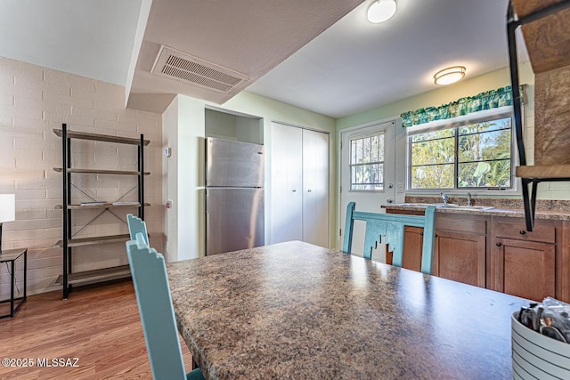 kitchen featuring light wood-type flooring and stainless steel fridge