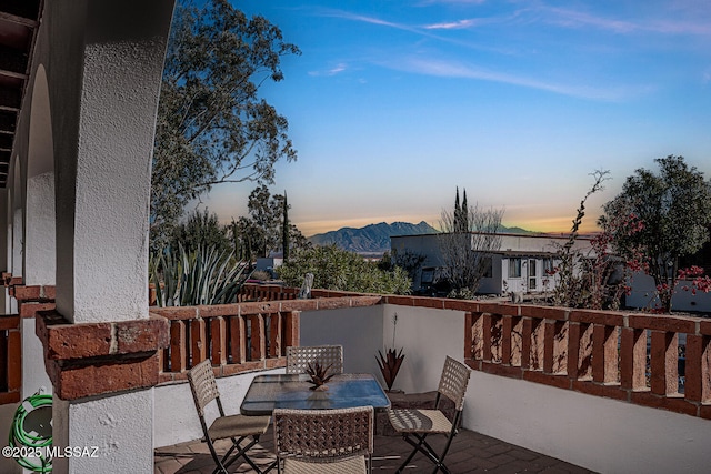 balcony at dusk featuring a mountain view