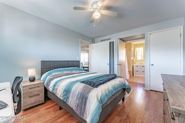 bedroom with ensuite bath, ceiling fan, and light hardwood / wood-style flooring