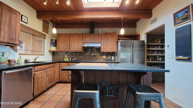 kitchen with a kitchen bar, sink, a center island, and appliances with stainless steel finishes