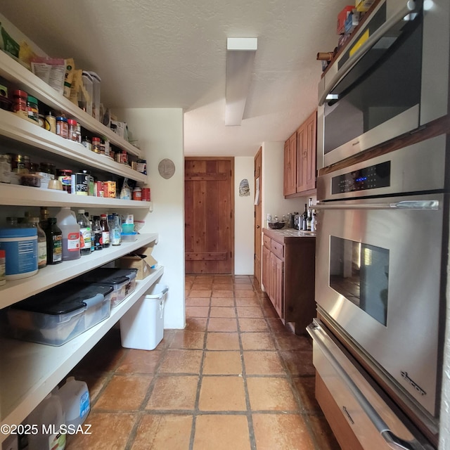 kitchen with a textured ceiling and appliances with stainless steel finishes