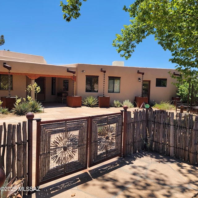 pueblo revival-style home featuring a patio