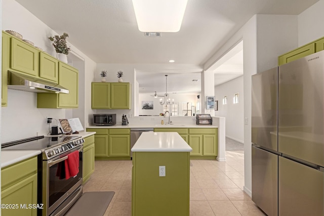 kitchen featuring sink, light tile patterned floors, appliances with stainless steel finishes, green cabinetry, and a kitchen island