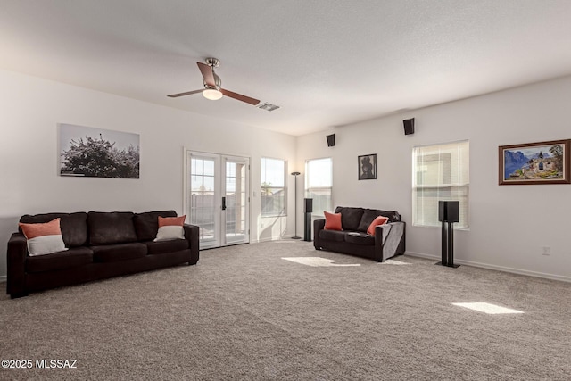 carpeted living room featuring a textured ceiling, ceiling fan, and french doors