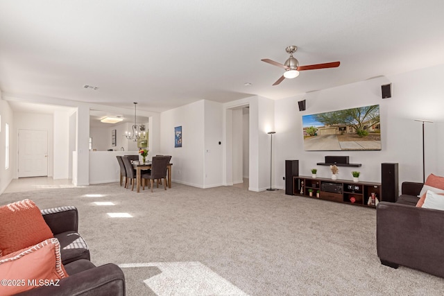 carpeted living room with ceiling fan with notable chandelier