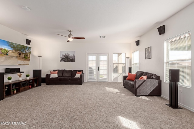 living room with light carpet, a wealth of natural light, french doors, and ceiling fan