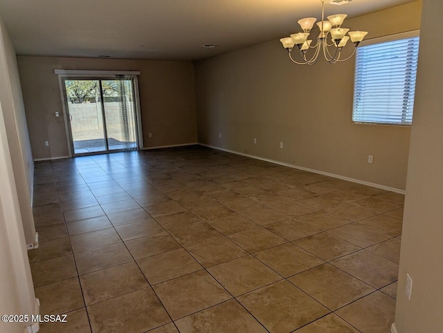 unfurnished room with tile patterned flooring and an inviting chandelier