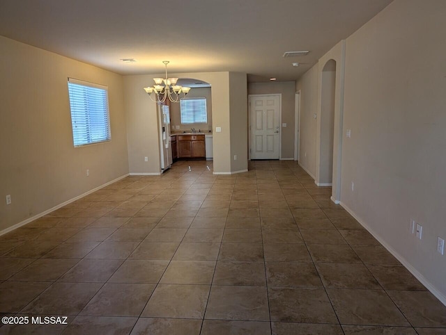 unfurnished dining area with tile patterned floors, a chandelier, and sink