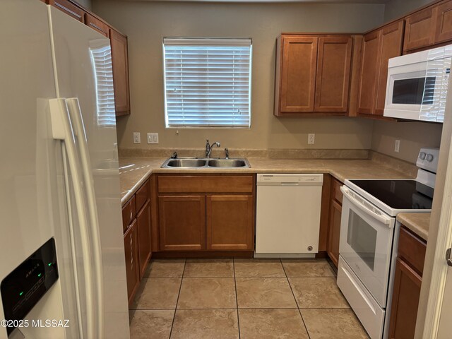 kitchen with light tile patterned flooring, sink, and white appliances