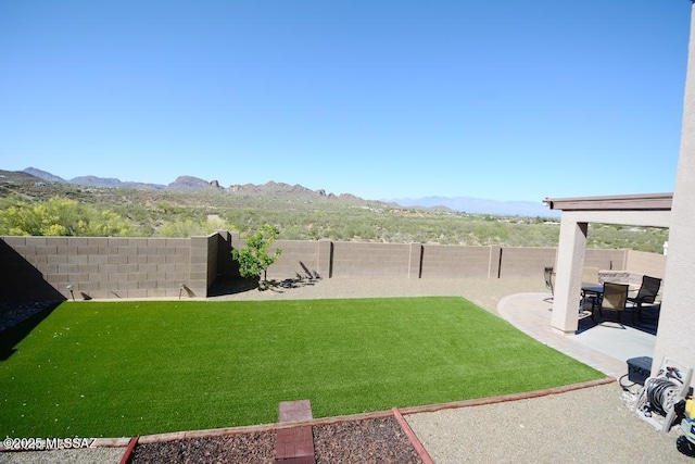 view of yard featuring a mountain view and a patio area