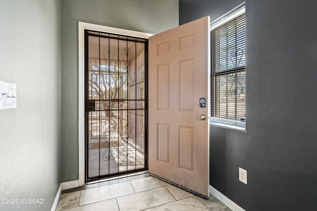 entryway with a wealth of natural light and light tile patterned floors