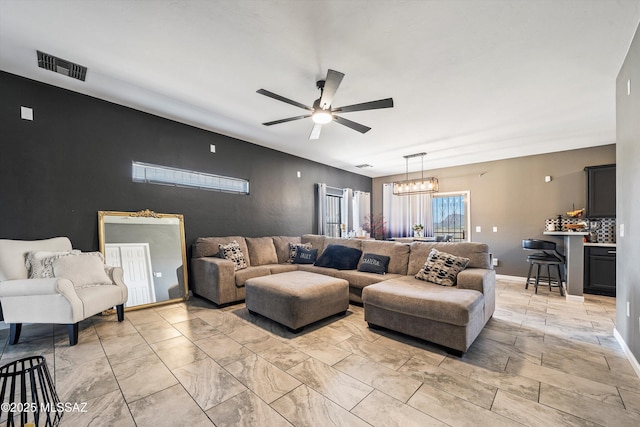 living room featuring ceiling fan with notable chandelier