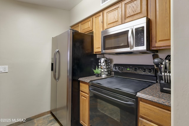 kitchen with stainless steel appliances and dark stone countertops