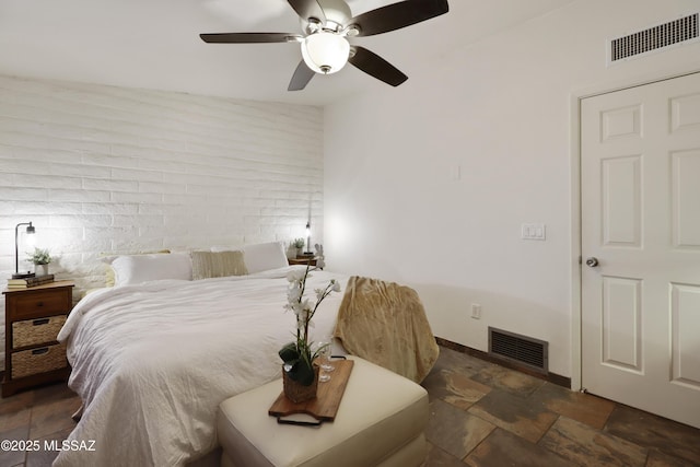 bedroom with lofted ceiling, ceiling fan, and brick wall