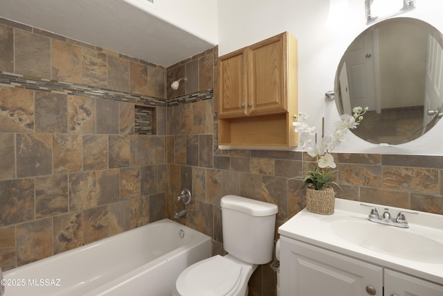 full bathroom with tiled shower / bath, tasteful backsplash, tile walls, vanity, and toilet