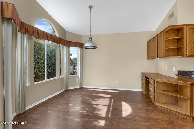 unfurnished dining area with lofted ceiling and dark hardwood / wood-style flooring