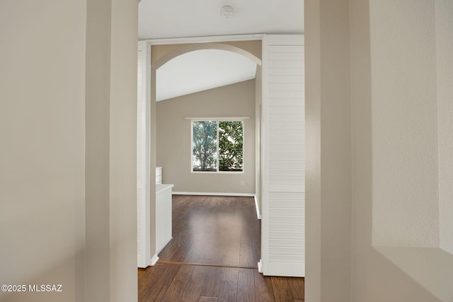 corridor featuring vaulted ceiling and dark hardwood / wood-style flooring